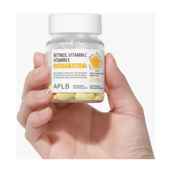 APLB Retinol Vitamin C Vitamin E Beauty 30 Tablets in hand with yellow beauty pills.